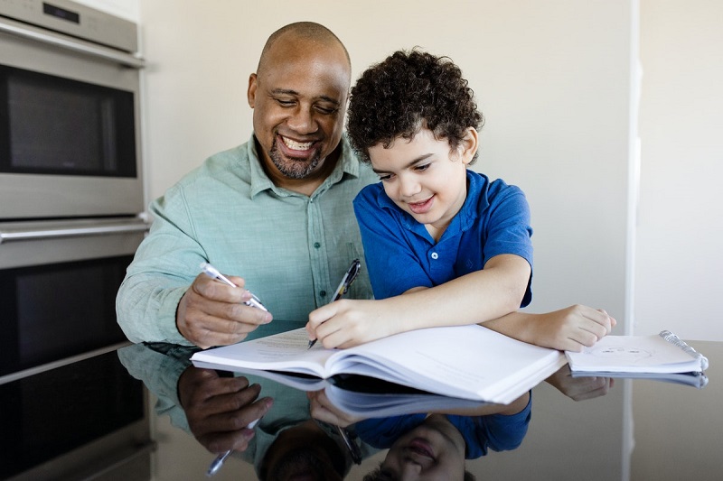 dad spends time with his son teaching him writing